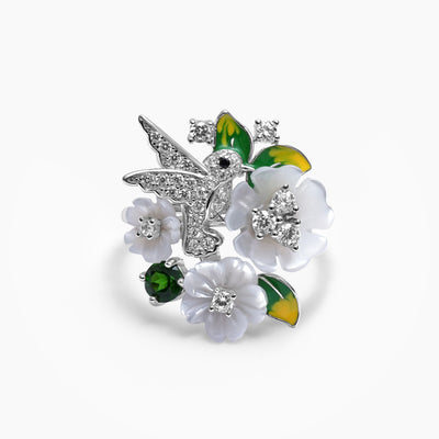 A sterling silver ring with a design of a bird and flowers, encrusted with zircons and mother of pearl, respectively.