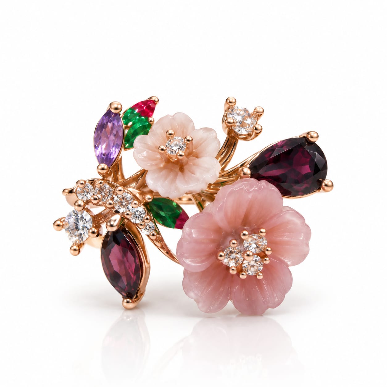 A floral rose gold brooch featuring two pink cabochon flowers, marquise-cut dark magenta garnet leaves, emerald-cut purple and green garnet accents, and small clear crystal clusters, shown on a white background with a soft reflection.