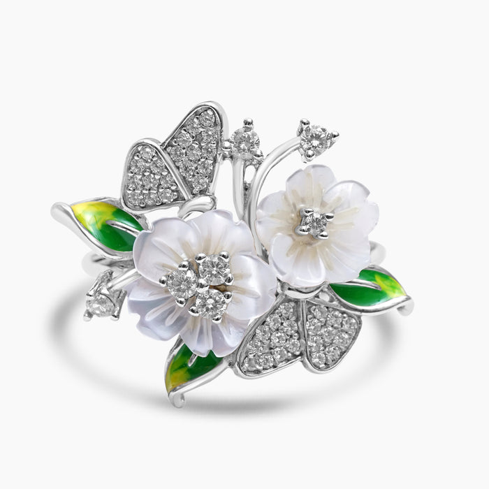 A silver ring featuring a floral design with mother of pearl flowers, enamel butterflies, and zircon embellishments.