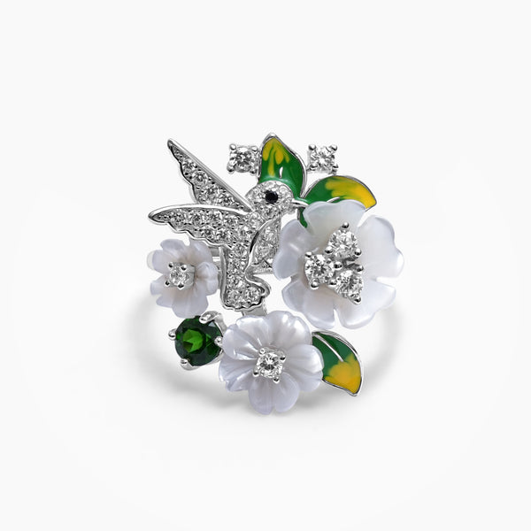 A sterling silver ring with a design of a bird and flowers, encrusted with zircons and mother of pearl, respectively.