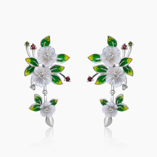 A pair of silver floral elegance earrings with enchanted blossom design, adorned with mother of pearl flowers, hand painted leaves, and sparkling zircon highlights.