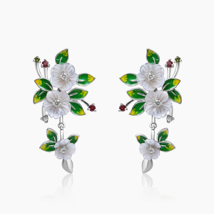 A pair of silver floral elegance earrings with enchanted blossom design, adorned with mother of pearl flowers, hand painted leaves, and sparkling zircon highlights.