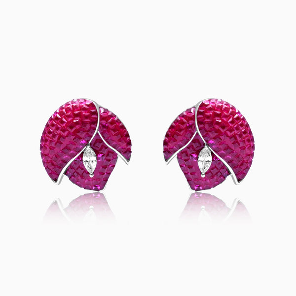 A pair of silver earrings with red flower designs and small white accents