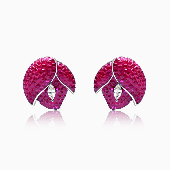 A pair of silver earrings with red flower designs and small white accents