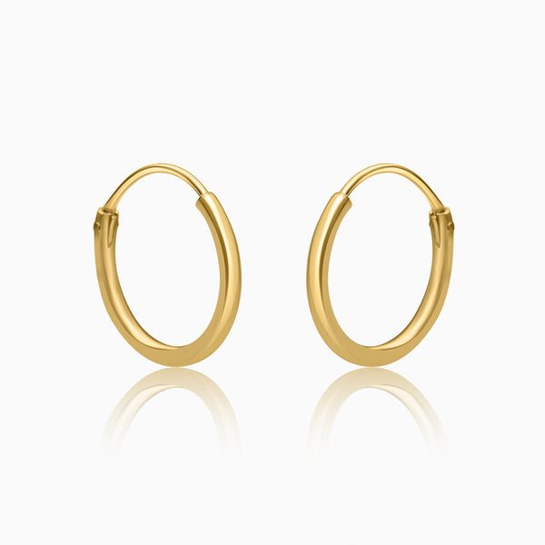 A pair of gold-colored hoop earrings on a white background