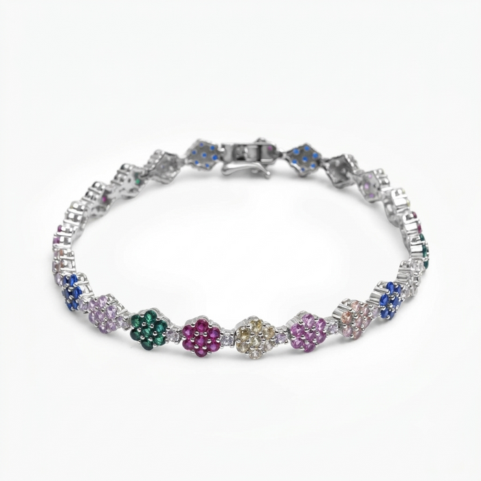 A silver-toned tennis bracelet featuring a series of colorful flower-shaped pavé settings with gemstones in blue, green, magenta, yellow, and pink, displayed on a clean white background.