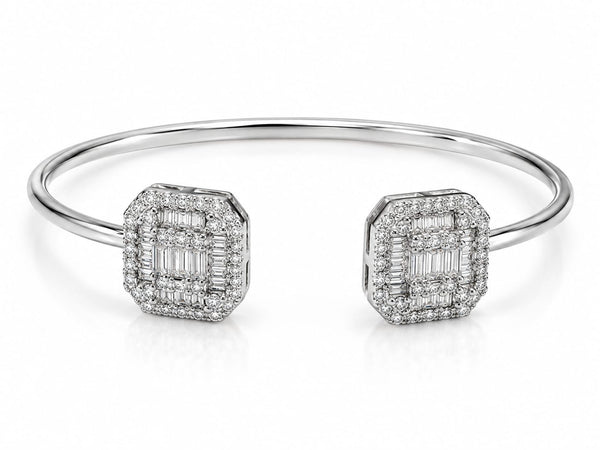A polished silver-tone cuff bracelet featuring two square-shaped pavé diamond end caps with baguette-cut center stones, set against a clean white background.